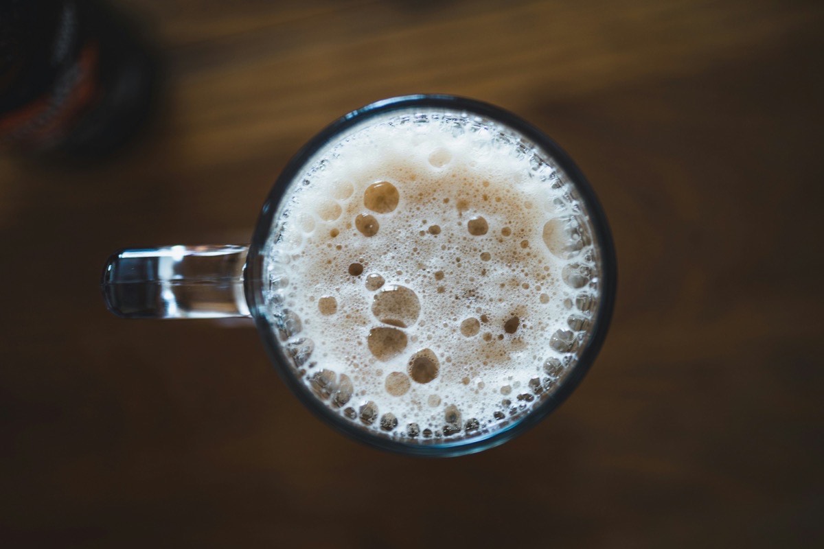 A clear glass mug filled with carbonated water, rising bubbles visible against a soft background